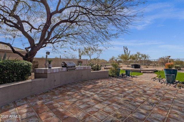 view of patio / terrace featuring a grill, central AC unit, an outdoor kitchen, and a fenced backyard