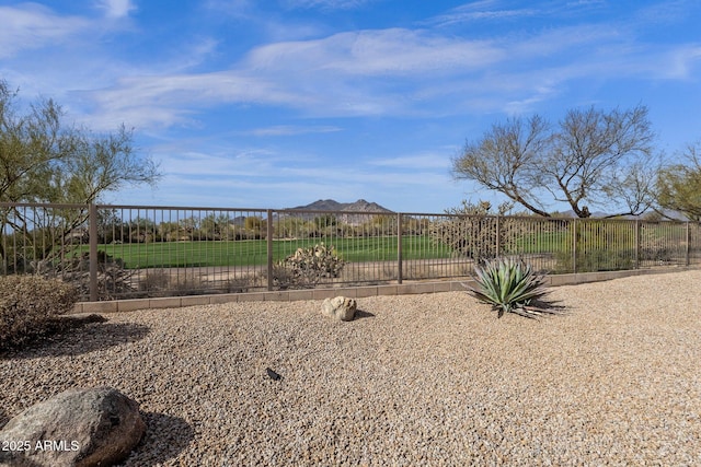 view of yard featuring fence and a mountain view