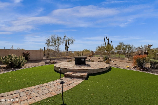 view of yard featuring an outdoor fire pit, a fenced backyard, and a patio area