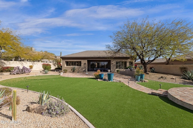 back of property with a lawn, a patio area, and fence