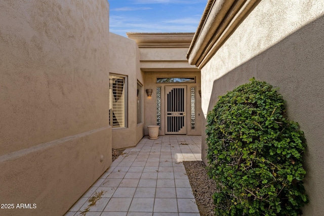 entrance to property featuring a patio area and stucco siding