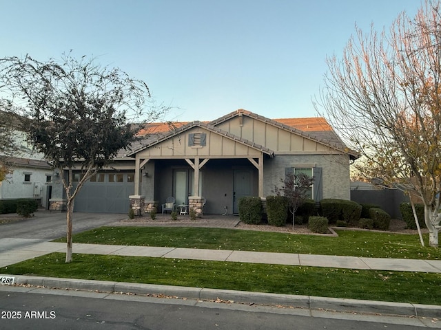 craftsman inspired home featuring a garage and a front lawn