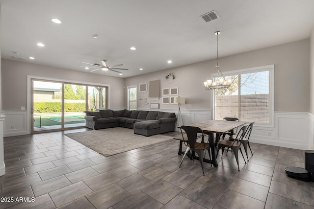 dining room with ceiling fan with notable chandelier