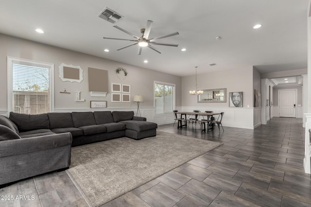 living room with ceiling fan with notable chandelier