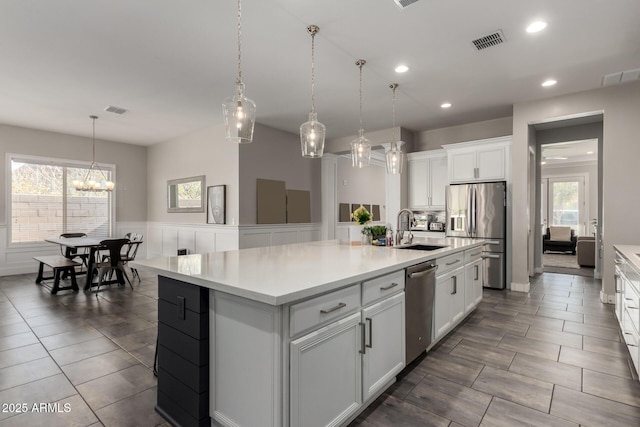 kitchen with white cabinets, an island with sink, appliances with stainless steel finishes, and sink