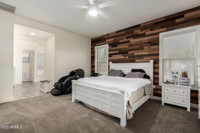 bedroom with ceiling fan, wood walls, and light colored carpet