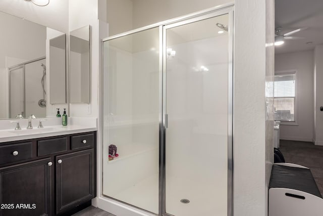 bathroom featuring a shower with shower door and vanity