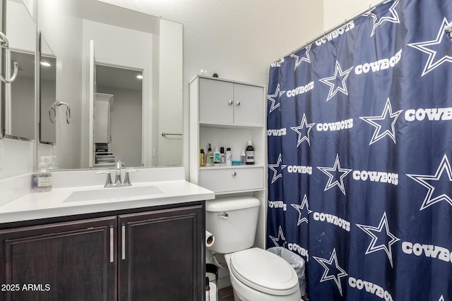 bathroom with toilet, vanity, and a shower with shower curtain