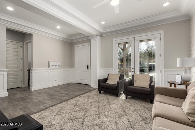 living room with decorative columns, ceiling fan, and ornamental molding