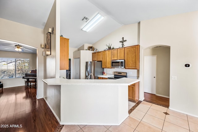 8479 E Sunrise Sky Dr, Gold Canyon, AZ 85118 - kitchen with lofted ceiling, appliances with stainless steel finishes, kitchen peninsula, and light tile patterned floors