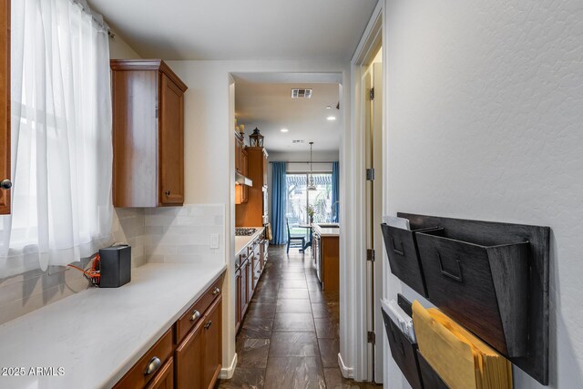 31332 N 137th Ln, Peoria, AZ 85383 - kitchen featuring brown cabinetry, backsplash, light countertops, under cabinet range hood, and recessed lighting