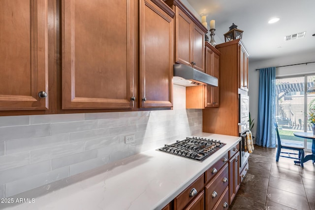 31332 N 137th Ln, Peoria, AZ 85383 - kitchen featuring appliances with stainless steel finishes, under cabinet range hood, brown cabinets, tasteful backsplash, and recessed lighting