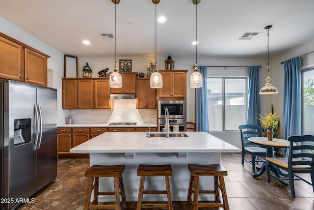 31332 N 137th Ln, Peoria, AZ 85383 - kitchen with stainless steel appliances, brown cabinetry, under cabinet range hood, backsplash, and light countertops