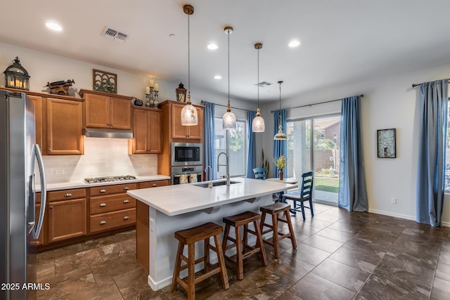 31332 N 137th Ln, Peoria, AZ 85383 - kitchen featuring appliances with stainless steel finishes, brown cabinetry, under cabinet range hood, light countertops, and recessed lighting