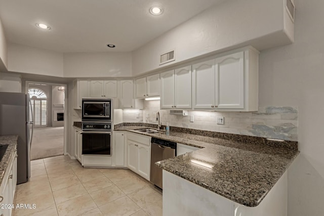 kitchen with black appliances, white cabinetry, and sink