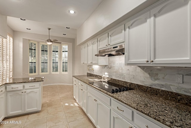 kitchen with tasteful backsplash, black electric stovetop, white cabinets, and dark stone counters