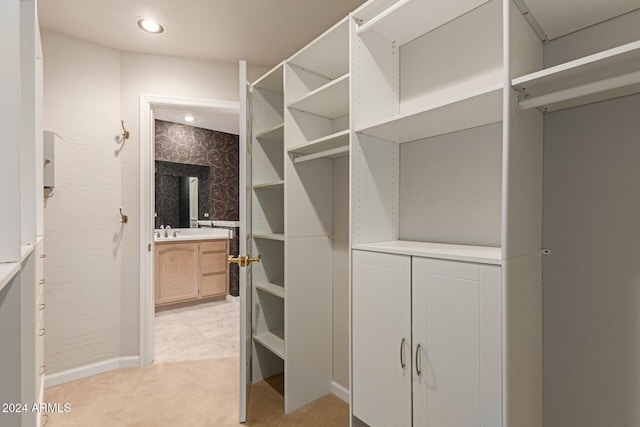 walk in closet featuring light carpet and sink