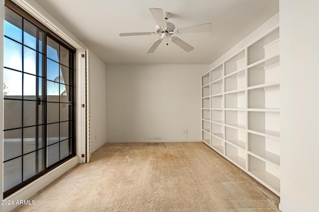 carpeted spare room with ceiling fan