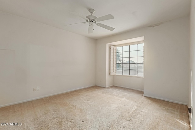 spare room featuring ceiling fan and light colored carpet