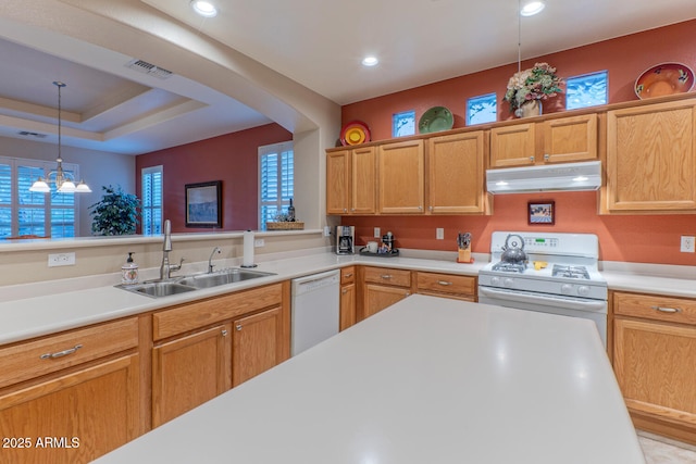 kitchen featuring pendant lighting, a raised ceiling, sink, an inviting chandelier, and white appliances