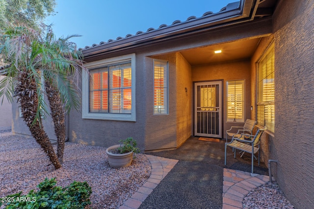 exterior entry at dusk featuring a patio area