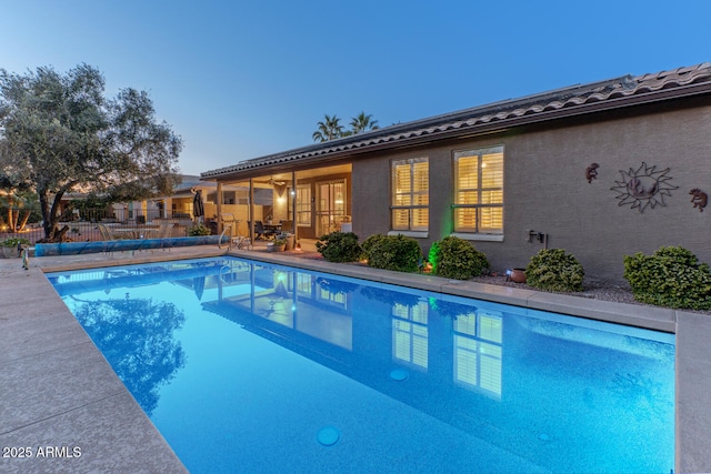 pool at dusk featuring a patio area