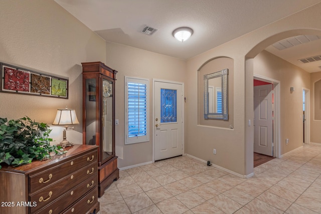 tiled entrance foyer with a textured ceiling