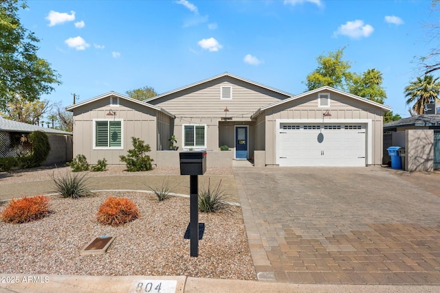 single story home with an attached garage, board and batten siding, and driveway