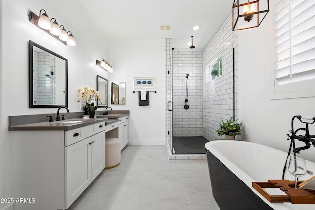 bathroom featuring a sink, a soaking tub, double vanity, and a shower stall