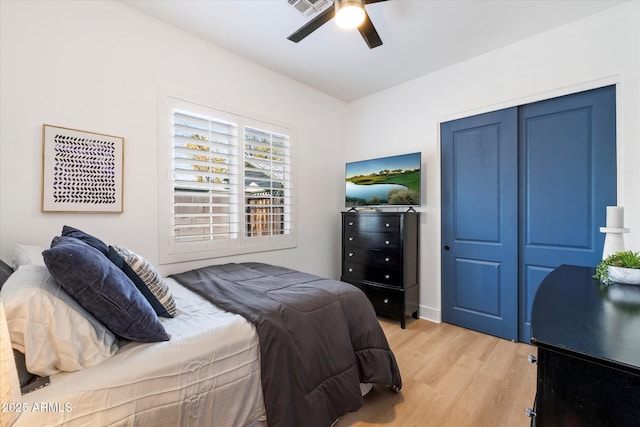 bedroom featuring light wood-type flooring, a closet, and ceiling fan