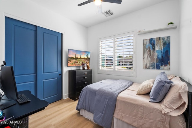 bedroom featuring a closet, visible vents, ceiling fan, and light wood-style floors