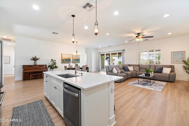 kitchen with visible vents, ceiling fan with notable chandelier, a sink, stainless steel dishwasher, and light wood finished floors