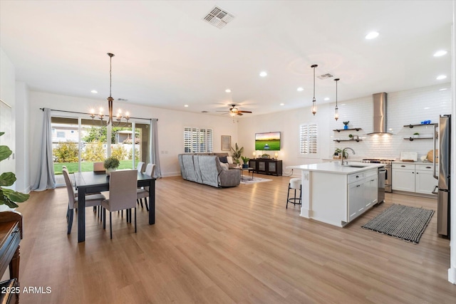 dining area with visible vents, recessed lighting, ceiling fan with notable chandelier, and light wood-style floors