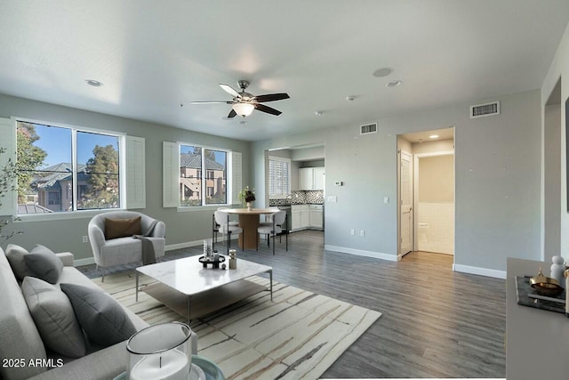 living room with ceiling fan and dark wood-type flooring