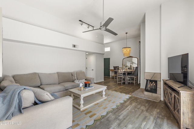 living room with a multi sided fireplace, dark hardwood / wood-style floors, and ceiling fan