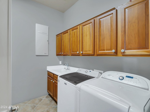 washroom with cabinets, washing machine and dryer, light tile patterned floors, and sink