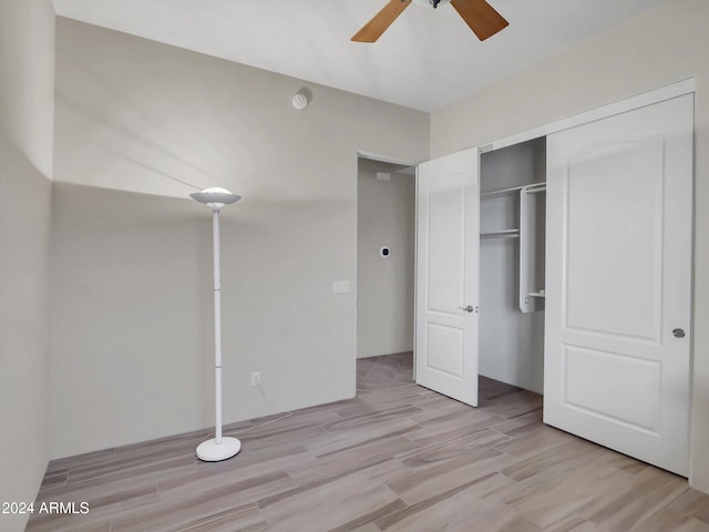 unfurnished bedroom with light hardwood / wood-style floors, ceiling fan, and a closet