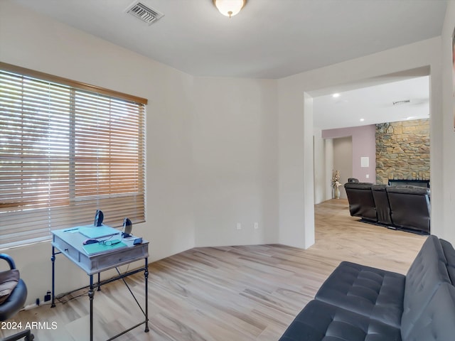 interior space featuring a stone fireplace and light hardwood / wood-style floors