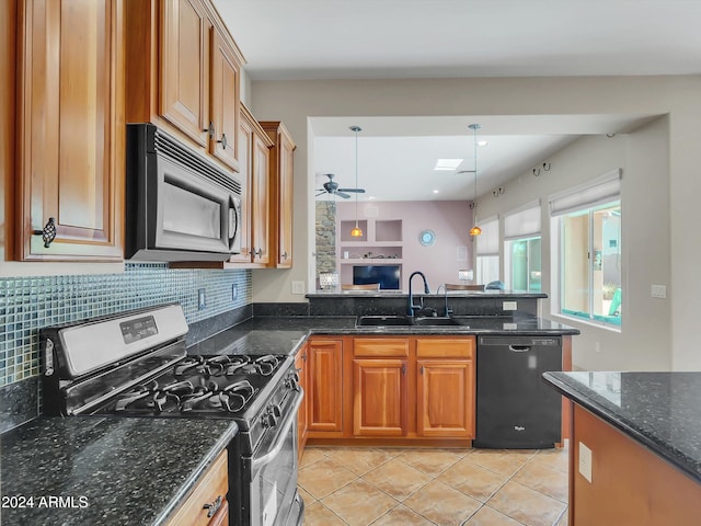 kitchen with black appliances, tasteful backsplash, dark stone counters, decorative light fixtures, and sink