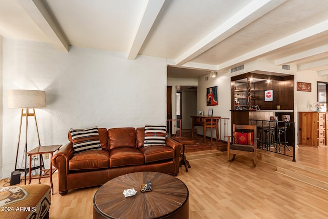 living room with beam ceiling, indoor bar, and light wood-type flooring