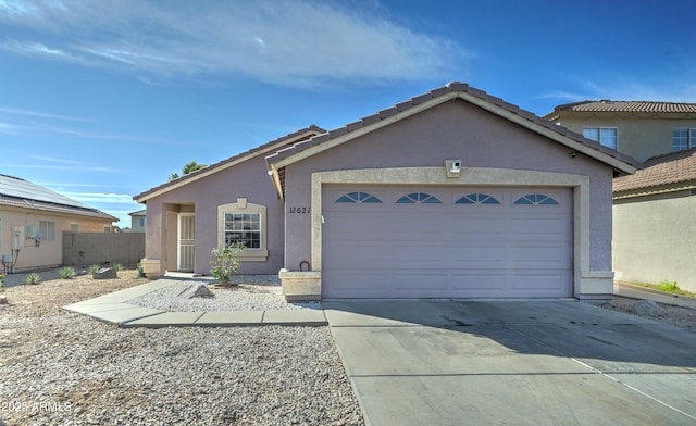 ranch-style home with driveway, an attached garage, and stucco siding