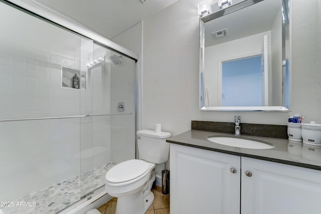 full bathroom with a stall shower, vanity, toilet, and tile patterned floors