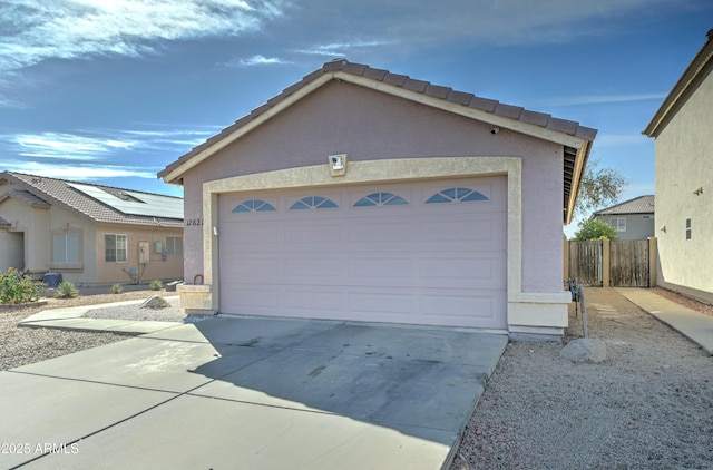 garage featuring driveway and fence