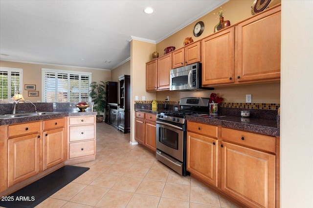 kitchen with light tile patterned flooring, ornamental molding, sink, and appliances with stainless steel finishes