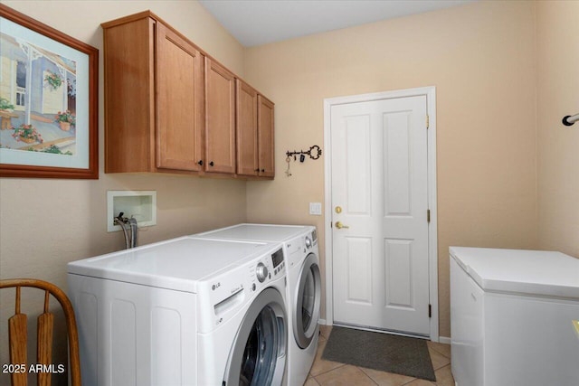 clothes washing area featuring cabinets, independent washer and dryer, and light tile patterned floors