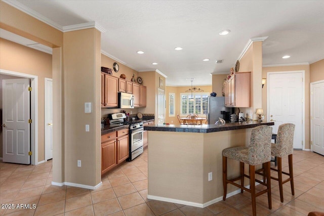 kitchen featuring kitchen peninsula, appliances with stainless steel finishes, ornamental molding, light tile patterned floors, and a breakfast bar area