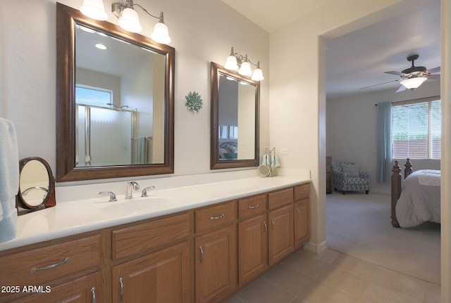 bathroom with tile patterned floors, ceiling fan, a shower with door, and vanity