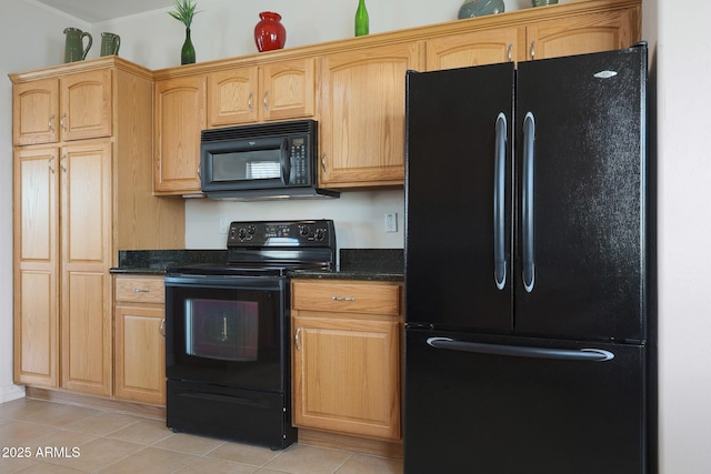 kitchen featuring light tile patterned floors, dark stone countertops, and black appliances