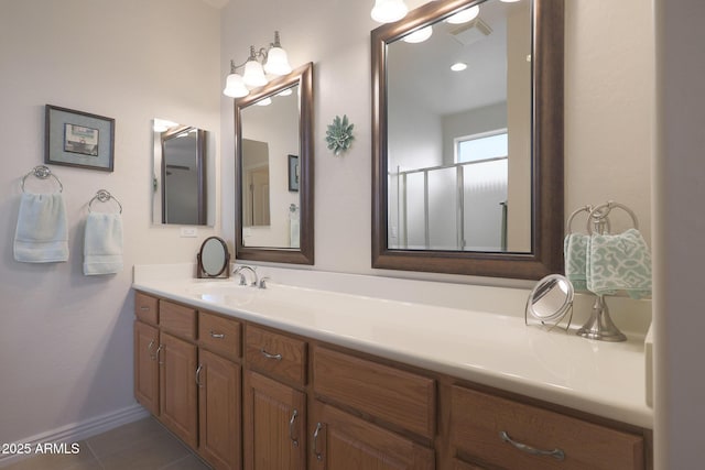 bathroom featuring tile patterned floors, a shower with door, and vanity