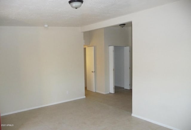 unfurnished room with a textured ceiling